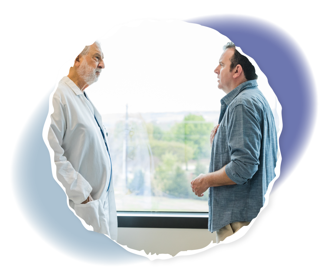 Eine Person steht einer anderen Person in weißem Kittel gegenüber. 