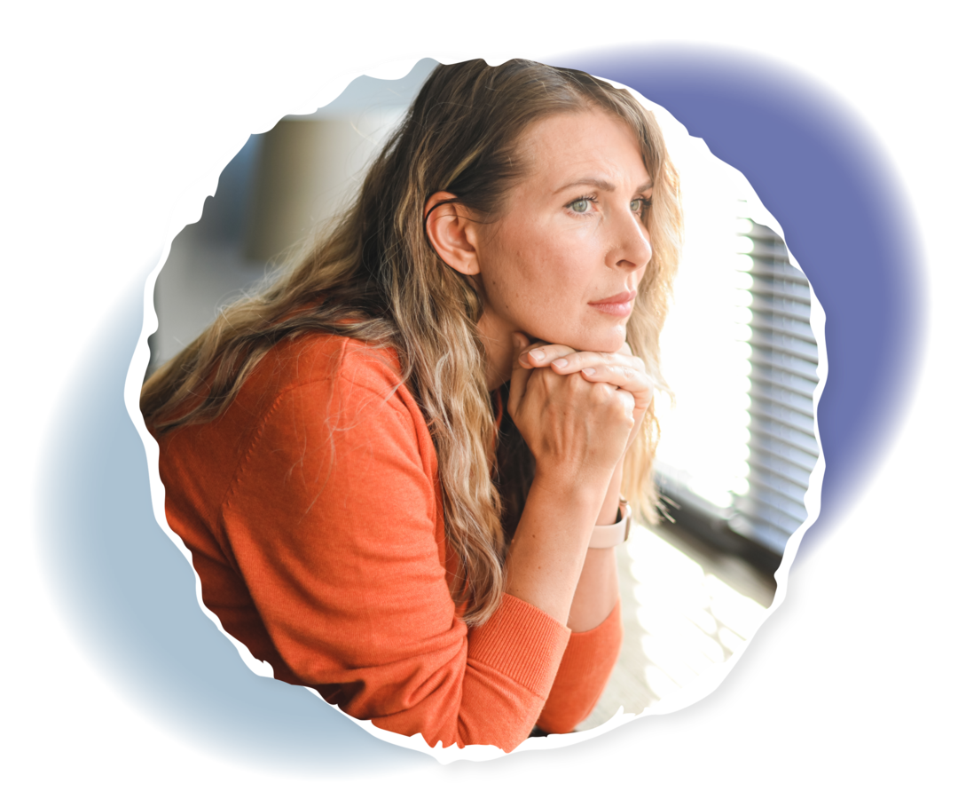 Eine Person hält den Kopf in die Hände gestützt und sieht aus dem Fenster. 