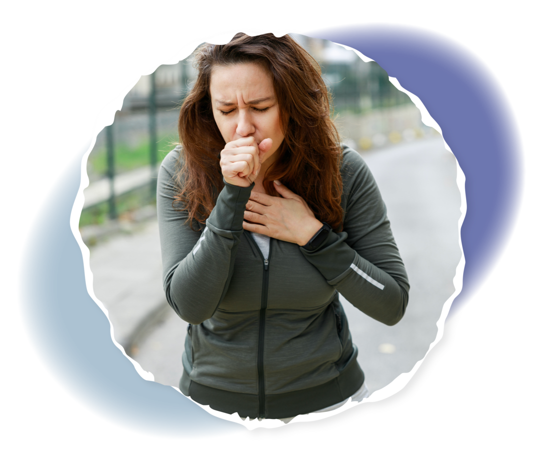 PNH: Atemnot Eine Person in Sportkleidung hält ihre Faust vor den Mund und fasst sich mit der anderen Hand an die Brust.