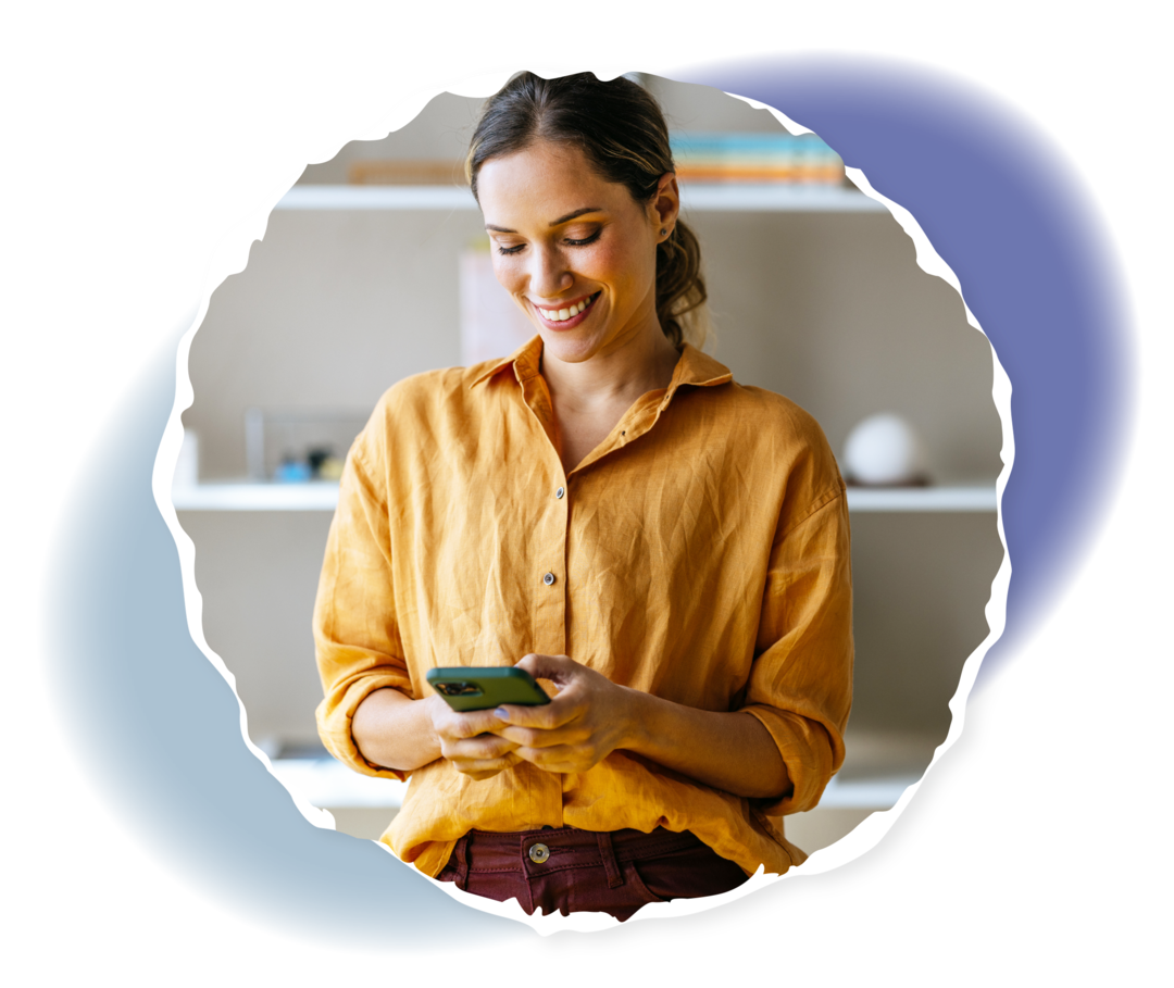 Eine Person hält ein Smartphone in der Hand und lächelt. 