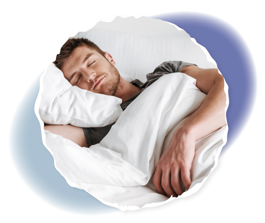 Ein junger Mann liegt schlafend in einem Bett mit weißer Bettwäsche.