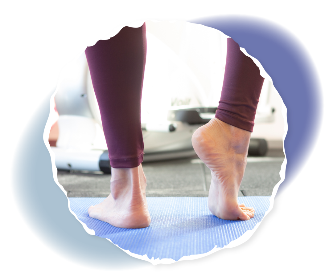 Füße stehen auf einer Gymnastikmatte. Bei einem Fuß ist die Ferse vom Boden abgehoben.