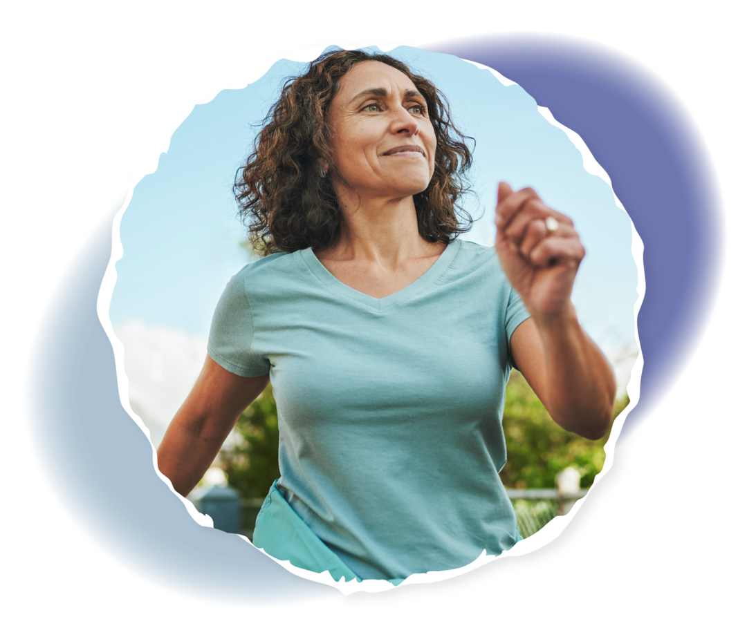 Lächelnde Frau, die ihre Arme am Körper vorbei schwingt. Im Hintergrund blauer Himmel.