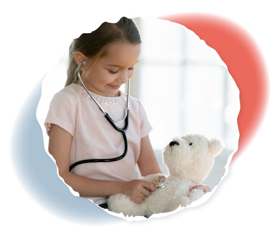 Ein junges Mädchen untersucht mit einem Stethoskop einen Teddybären.