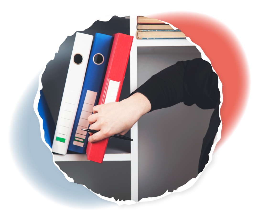 Eine Frau nimmt einen Ordner aus einem Regal.