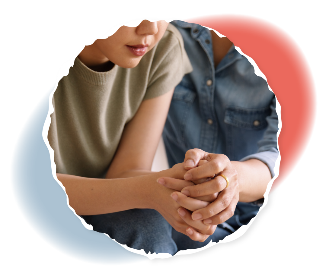 Eine Frau legt ihren Arm um ein junges Mädchen.