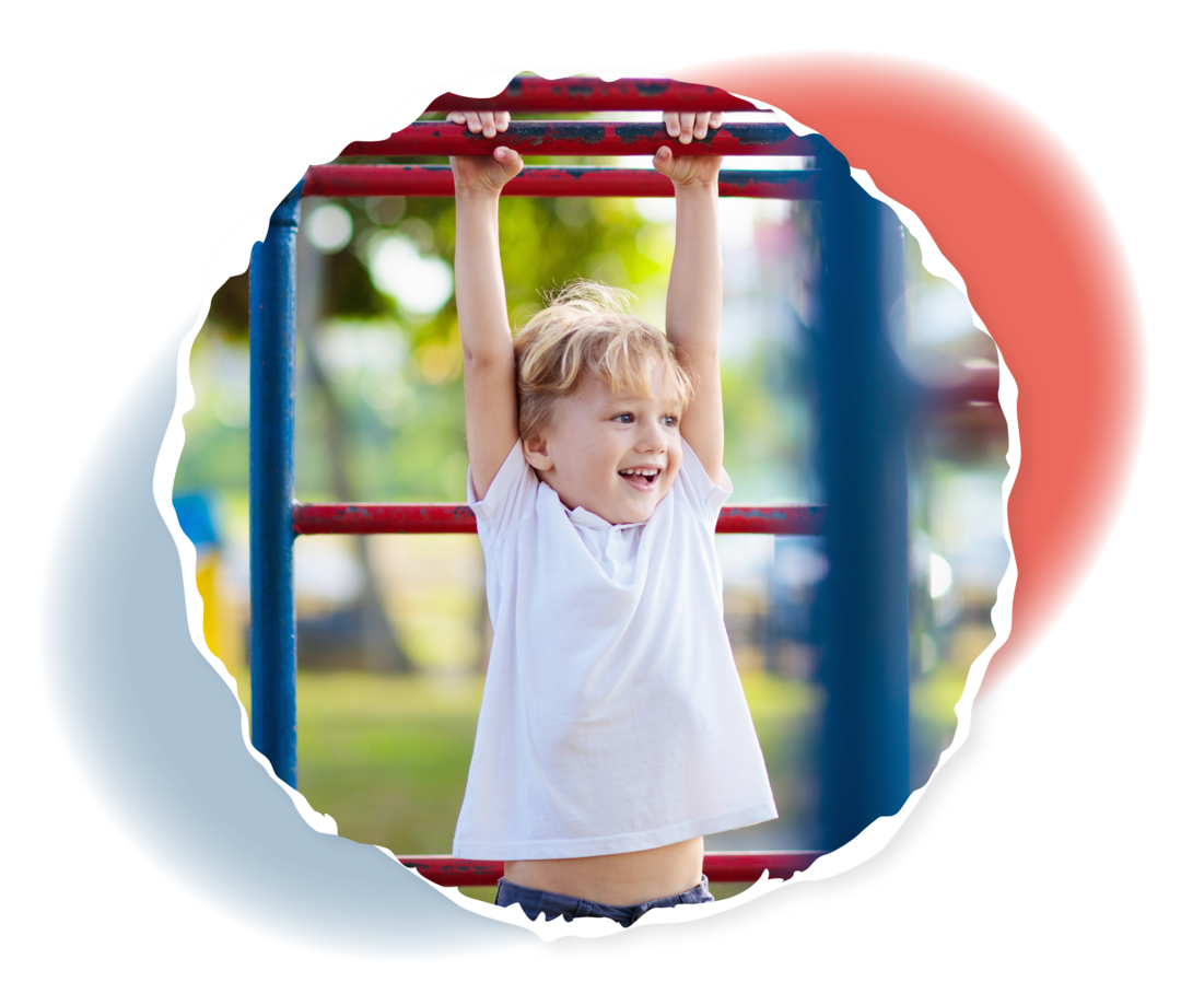 Ein Kind hängt mit den Händen an den Sprossen eines Klettergerüsts.