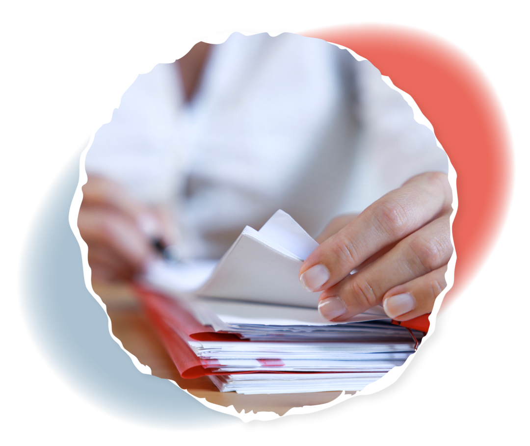 Eine Frau hält verschiedene Unterlagen auf einem Schreibtisch.