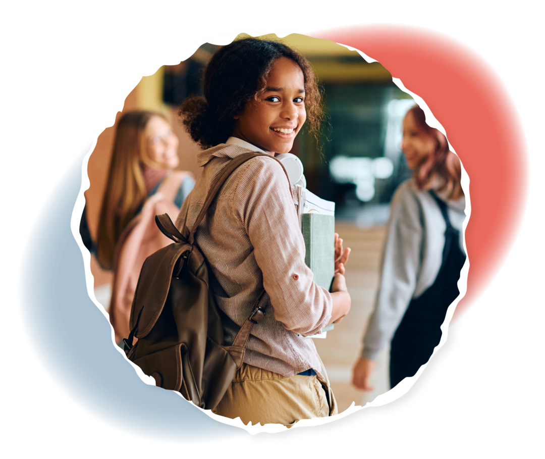 Eine Gruppe Jugendlicher läuft einen Flur entlang. Eine von ihnen dreht sich um und lächelt in die Kamera.