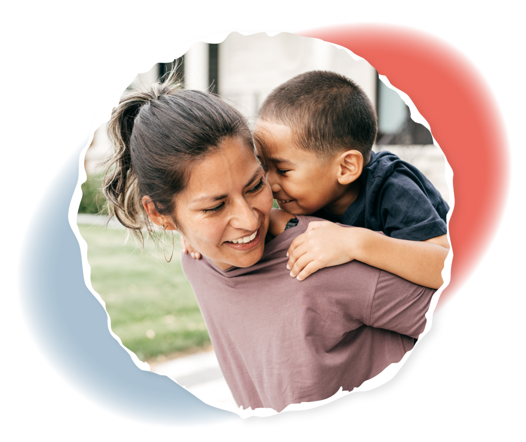 Eine Frau trägt einen Jungen auf ihrem Rücken. 