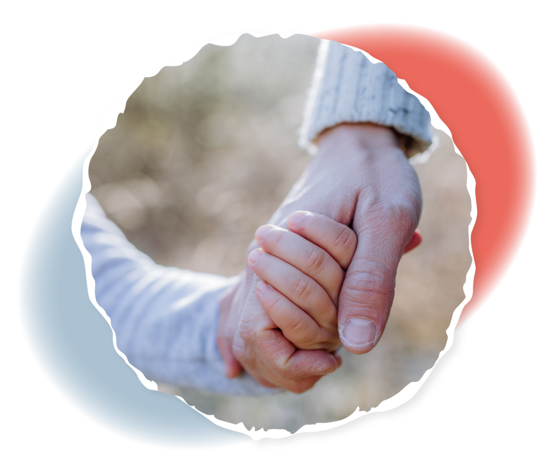 Ein Kind hält die Hand einer erwachsenen Person.