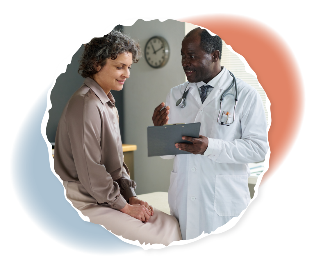 Eine Person sitzt auf einer Liege, eine andere Person in weißem Kittel steht vor ihr und hält ein Klemmbrett in der Hand.