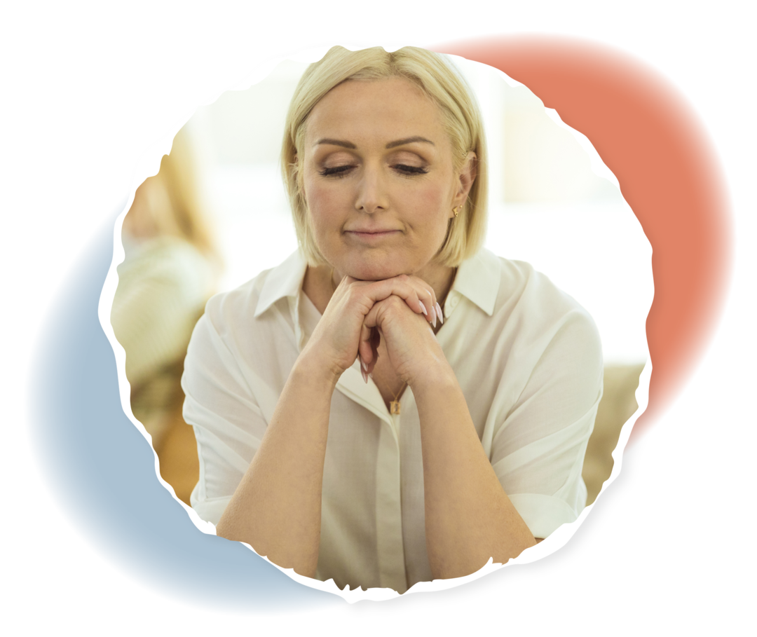 Eine ältere Person sitzt auf dem Sofa und hält den Kopf in die Hänge gestützt.