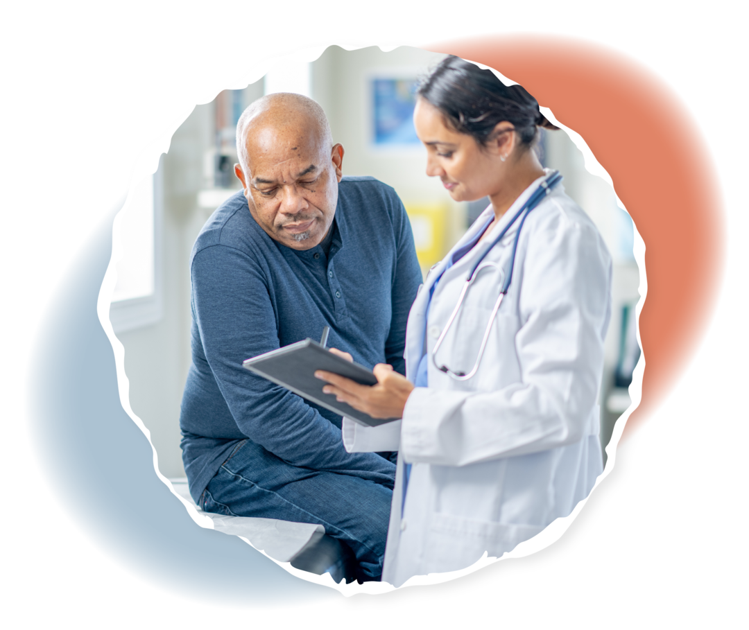 Eine ältere Person sitzt auf einer Liege, während eine andere Person in weißem Kittel ihr etwas auf einem Klemmbrett zeigt. 