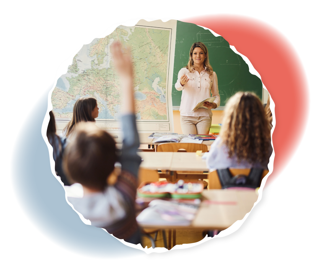 Eine Lehrerin steht vor einer Schulklasse. Einige der Kinder heben den Arm. 