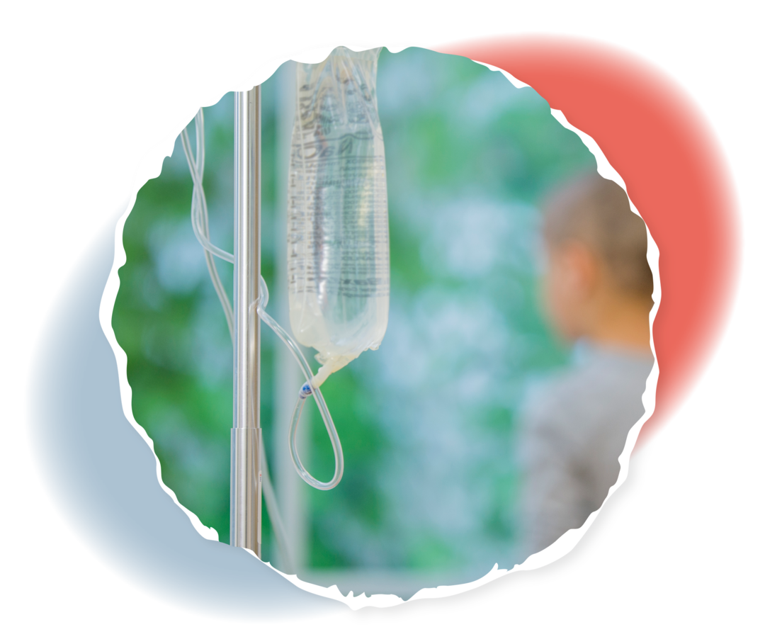 Im Vordergrund ein Infusionsbeutel, im Hintergrund ein Kind, das aus dem Fenster schaut.