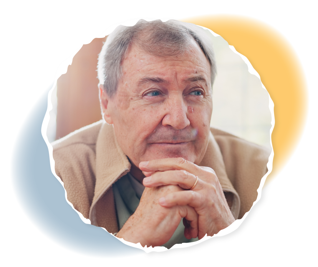 Ein älterer Mann faltet die Hände und schaut nachdenklich.