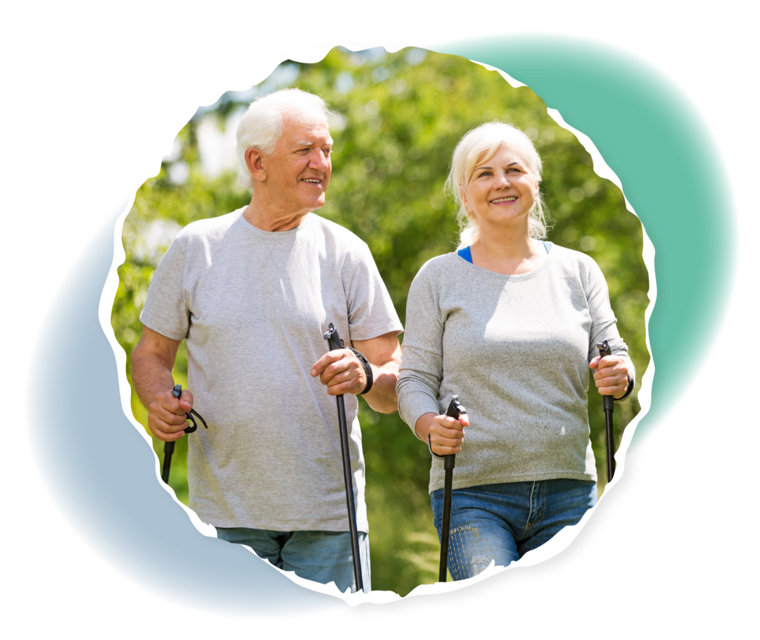 Zwei ältere Menschen beim Nordic Walking in einem Wald.