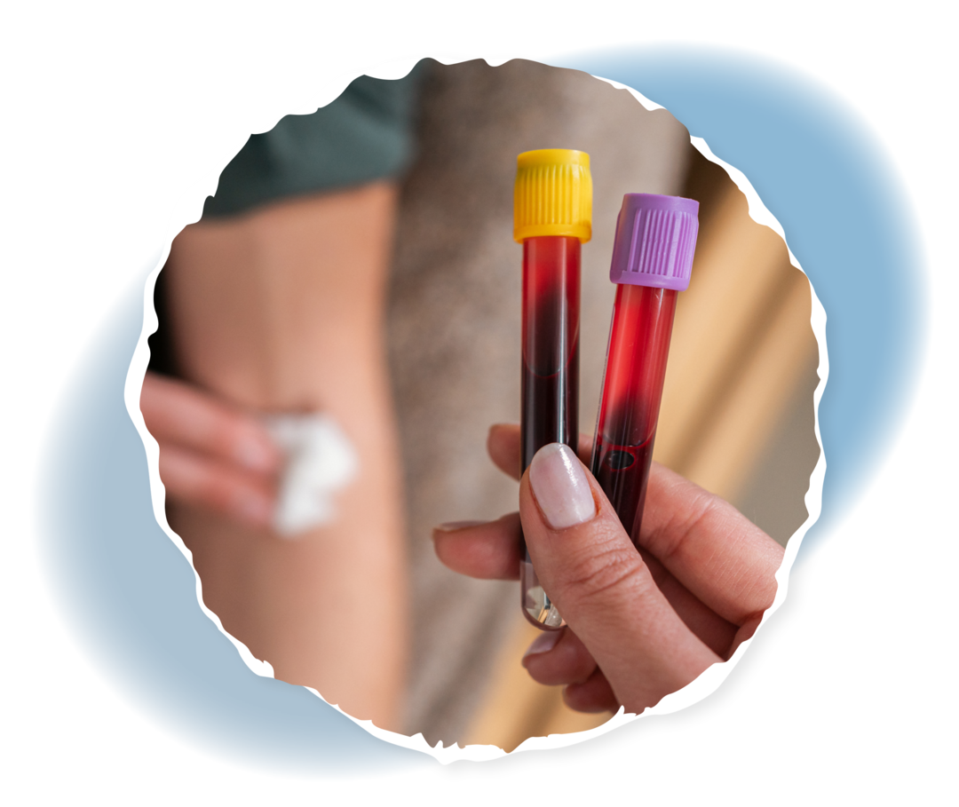 Im Vordergrund zwei Blutproben. Im Hintergrund drückt ein Mann einen Tupfer in seine Ellenbeuge.