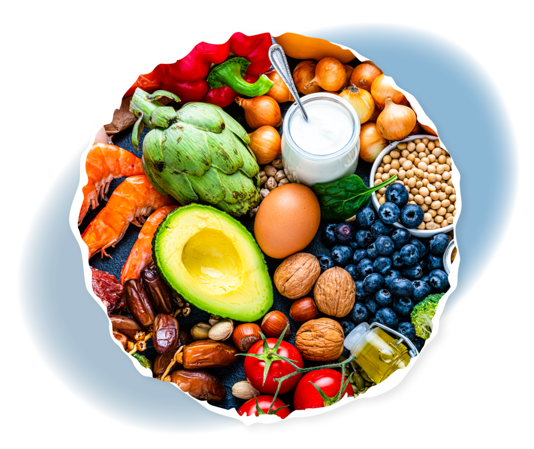 Verschiedene Nahrungsmittel wie Fleisch, verschiedenes Gemüse und Obst sowie Nüsse auf einem Tisch.