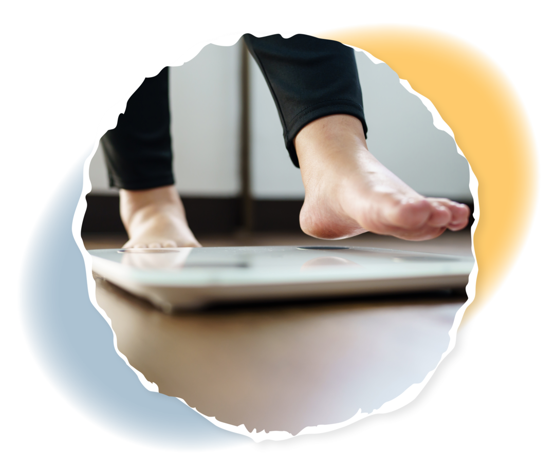 Eine Person in Jeans steht auf einer Personenwaage, nur die Beine sind sichtbar.