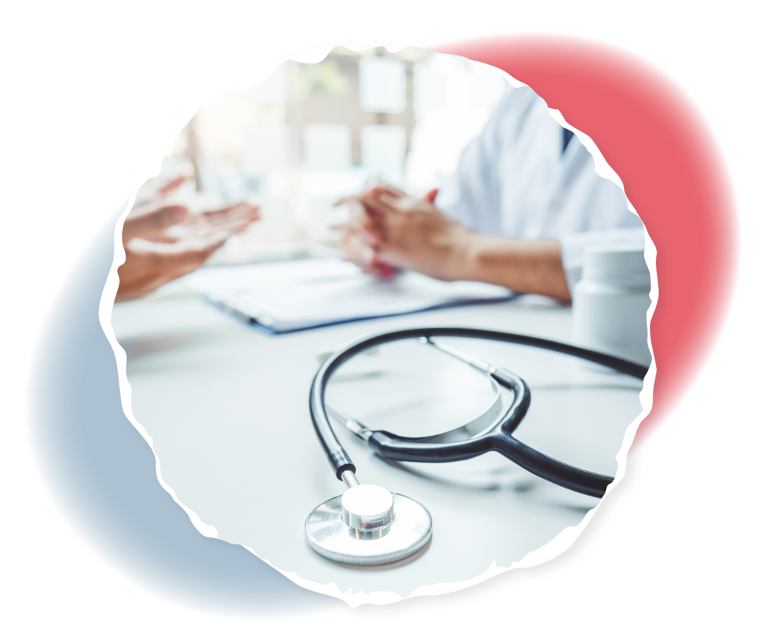 Ein Arzt und ein Patient sitzen sich gegenüber. Auf dem Tisch zwischen ihnen liegt ein Stethoskop.