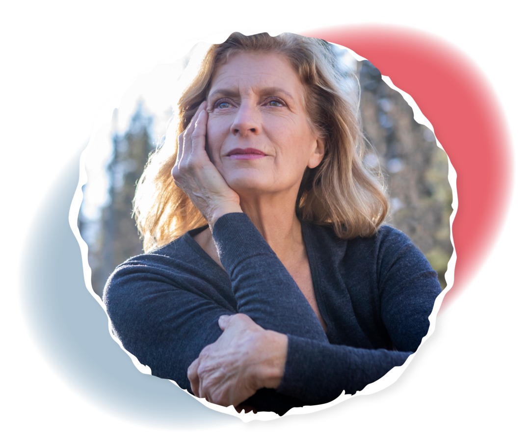 Eine ältere Frau stützt ihren Kopf auf eine Hand und schaut nachdenklich in die Ferne.